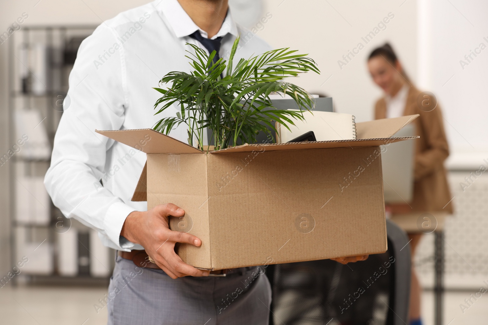 Photo of Unemployment problem. Man with box of personal belongings in office, closeup