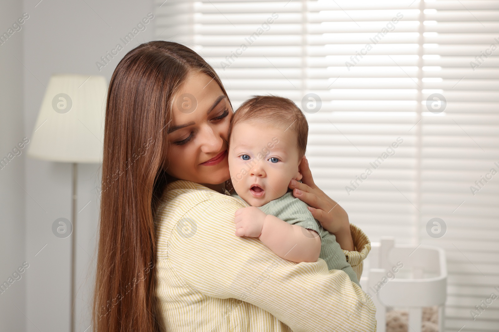 Photo of Mother holding her cute newborn baby at home