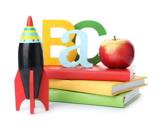 Bright toy rocket and school supplies on white background