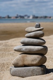 Photo of Stack of stones on beautiful sandy beach near sea