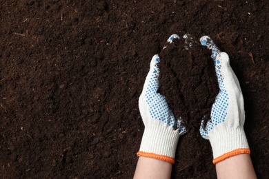 Photo of Woman holding fertile soil in hands, closeup with space for text. Gardening season