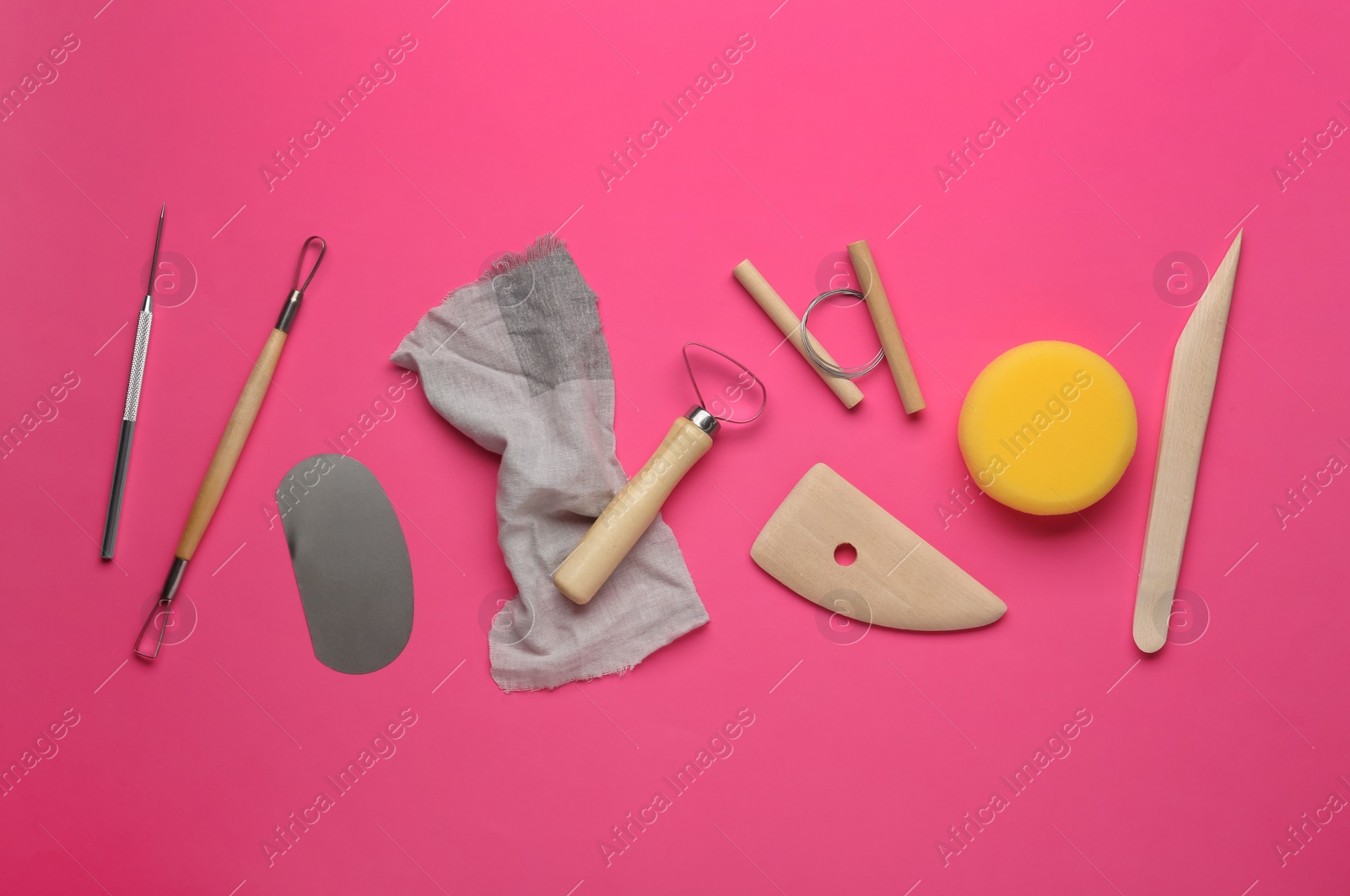 Photo of Set of clay modeling tools on pink background, flat lay