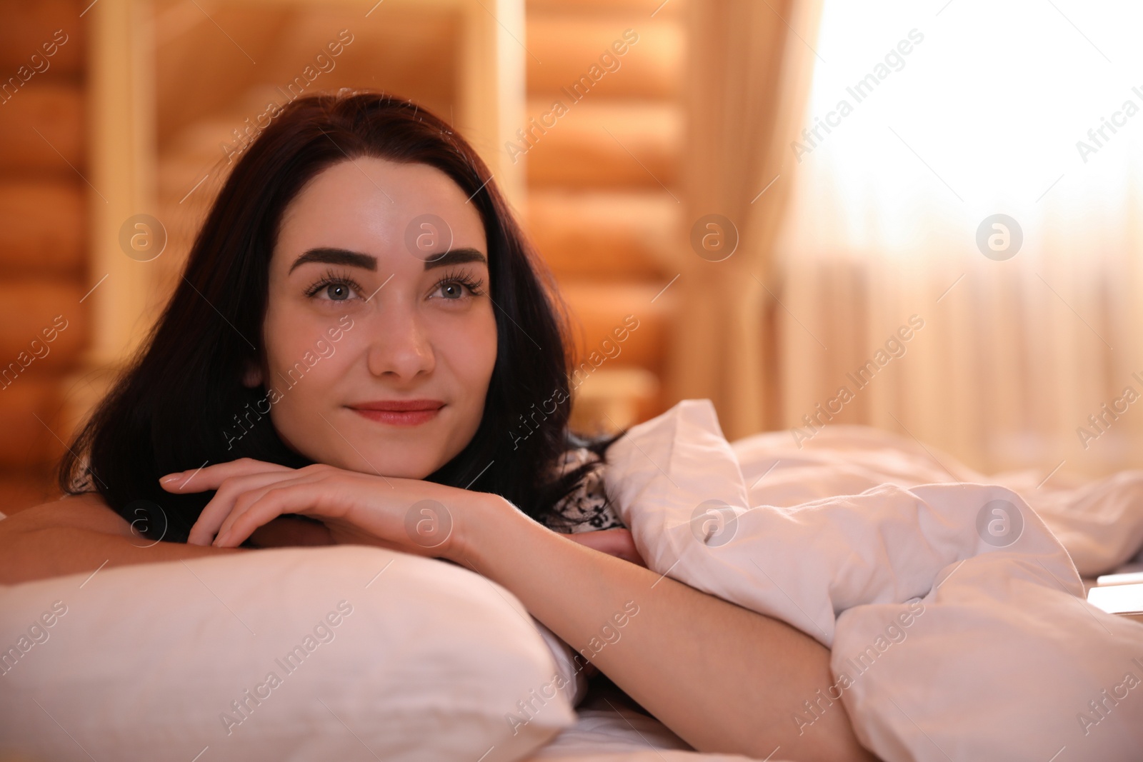 Photo of Young woman lying in bed at home. Lazy morning