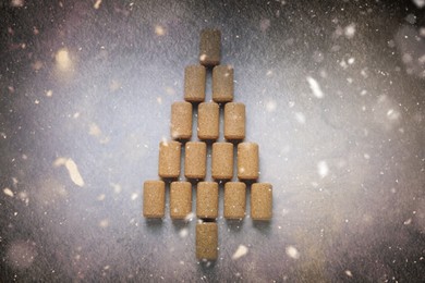 Christmas tree made of wine corks on light grey table, top view