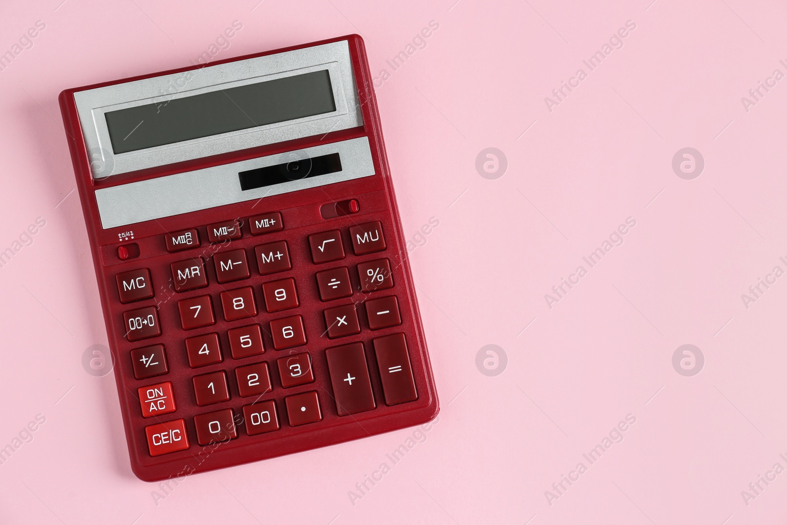 Photo of Red calculator on pink background, top view. Space for text