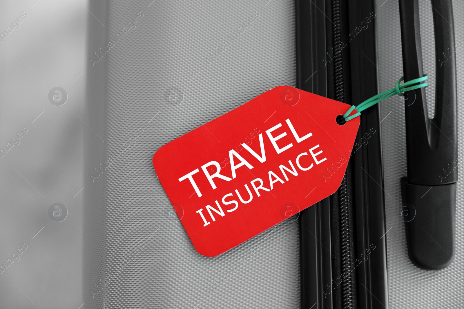 Photo of Stylish suitcase with travel insurance label on blurred background, closeup. Space for text