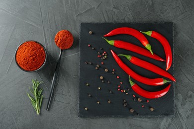 Photo of Ground red pepper and ingredients on grey table, flat lay