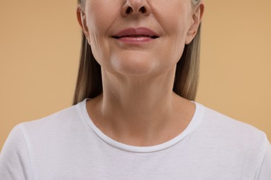 Photo of Mature woman with healthy skin on beige background, closeup