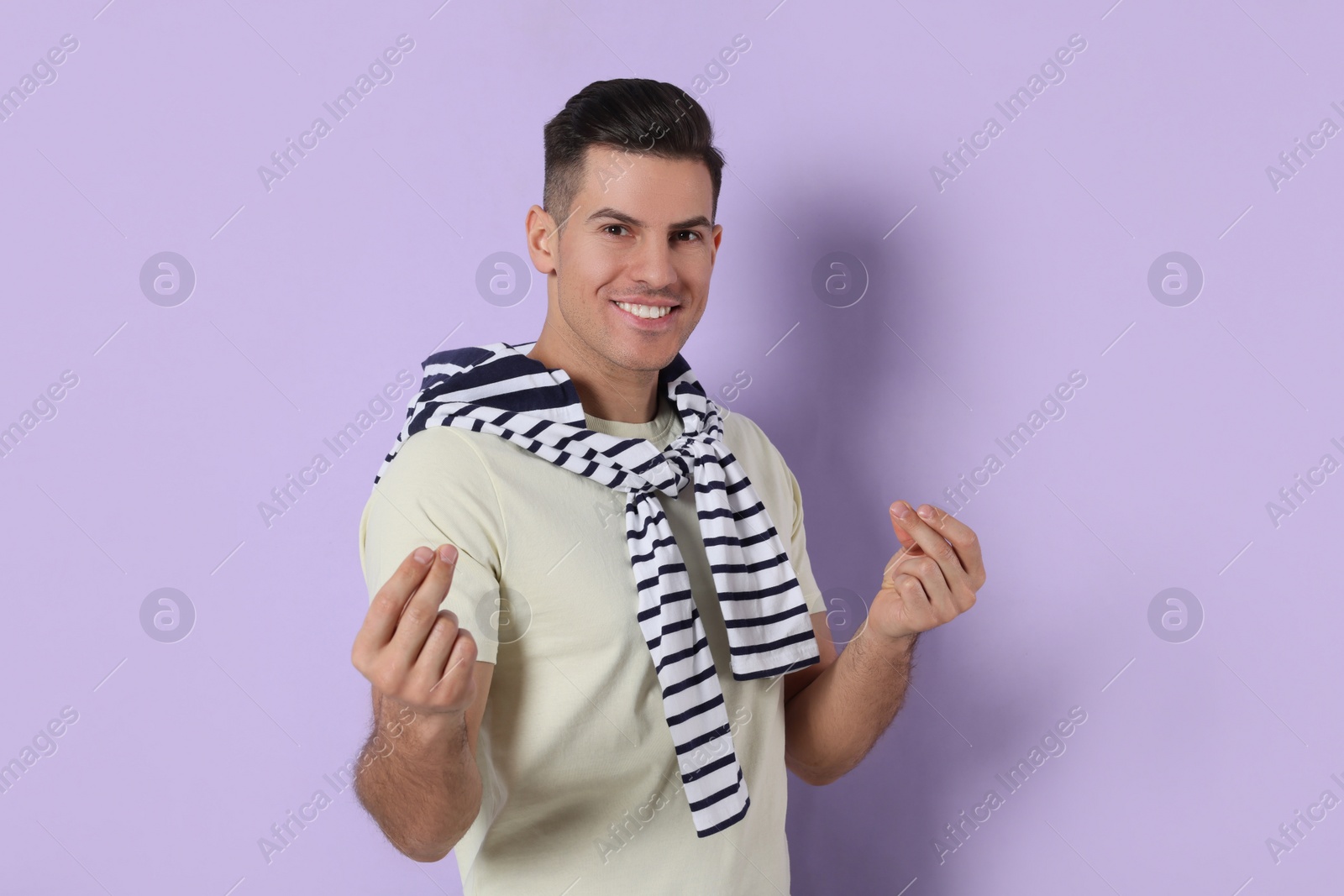 Photo of Handsome man snapping fingers on violet background