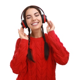 Young woman listening to music with headphones on white background