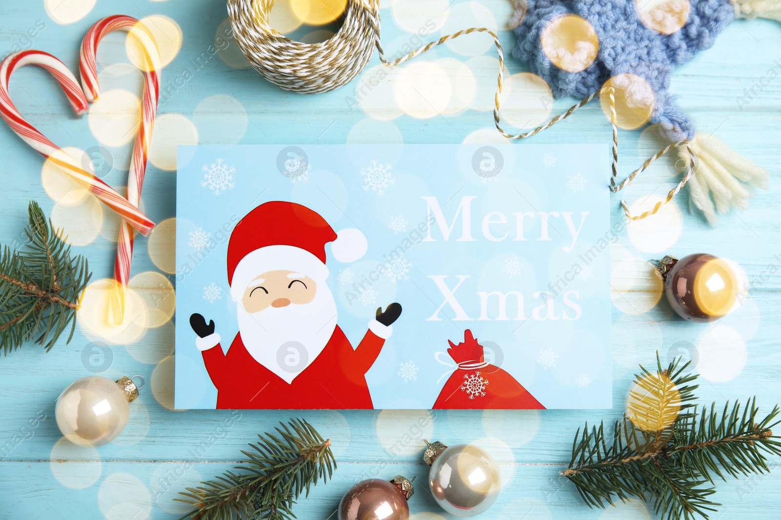 Photo of Flat lay composition with Christmas card and festive decor on light blue wooden background