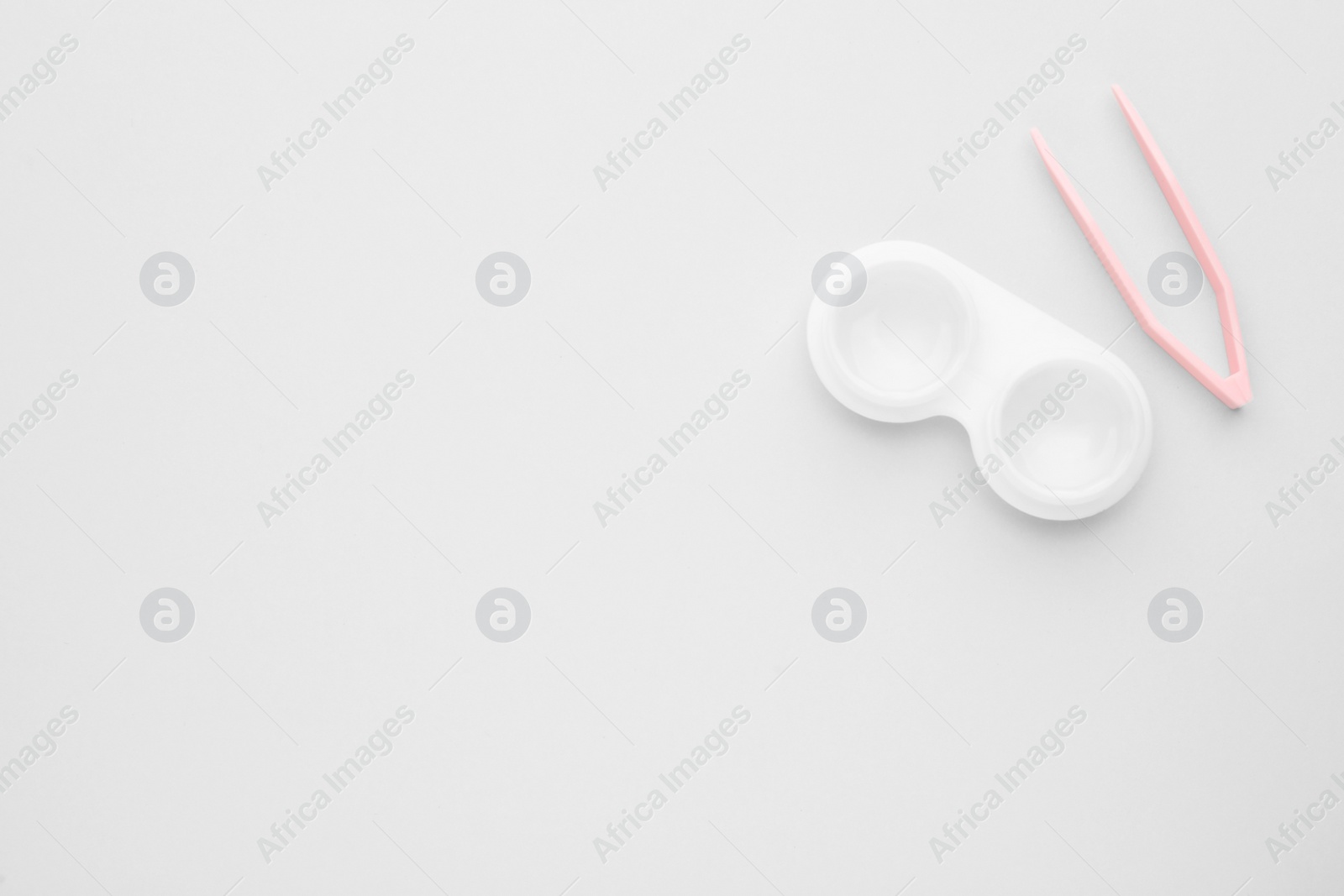 Photo of Case with contact lenses and tweezers on white background, flat lay. Space for text