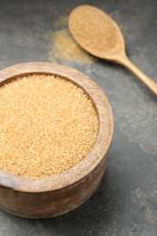 Photo of Brown sugar in bowl on grey table, closeup