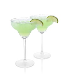 Photo of Delicious Margarita cocktail in glasses, salt and lime isolated on white