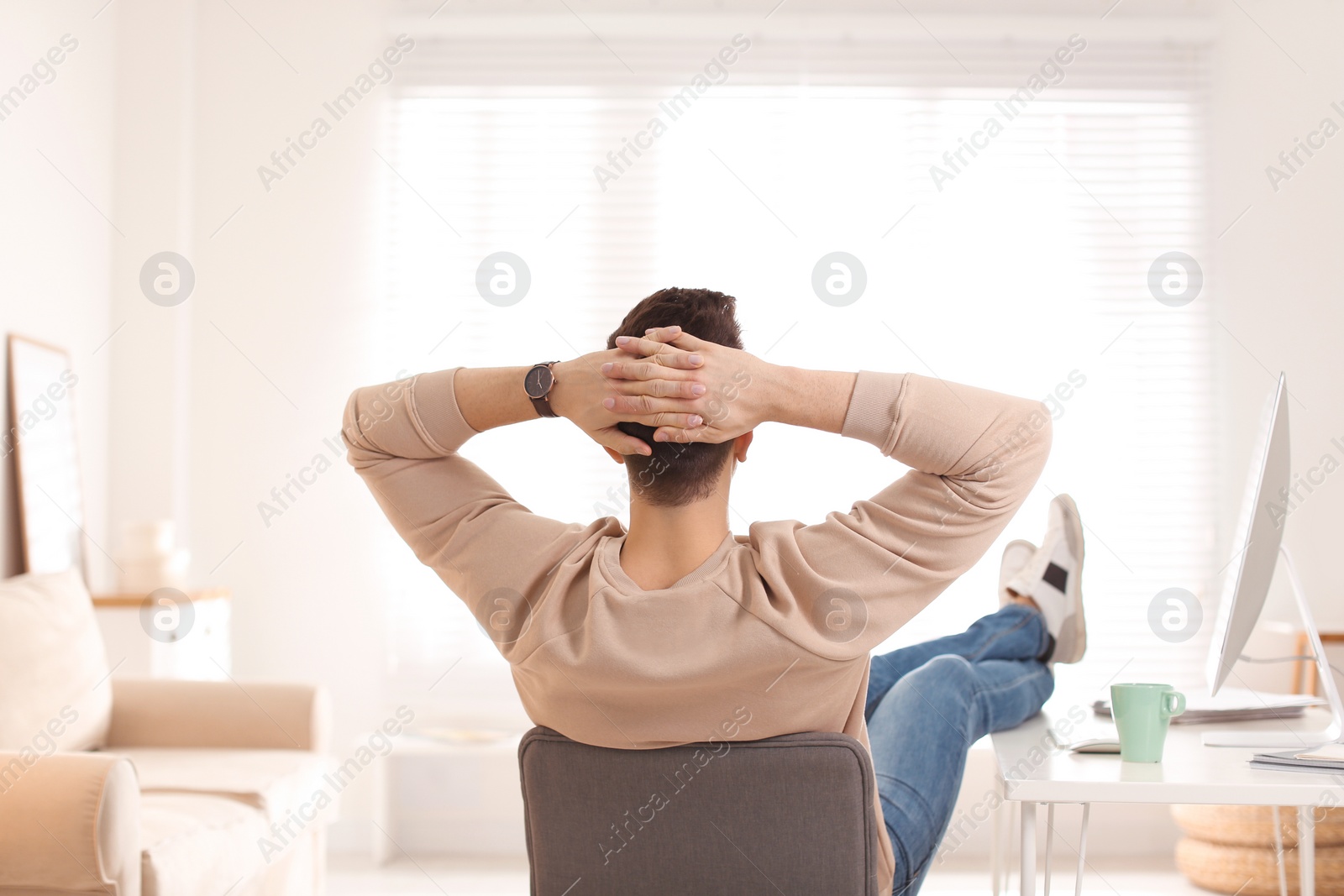 Photo of Young man relaxing at table in office during break