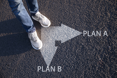 Choosing between Plan A and Plan B. Man near pointers on road, closeup view