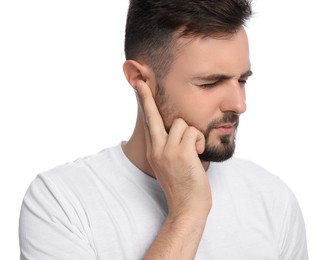 Young man suffering from ear pain on white background