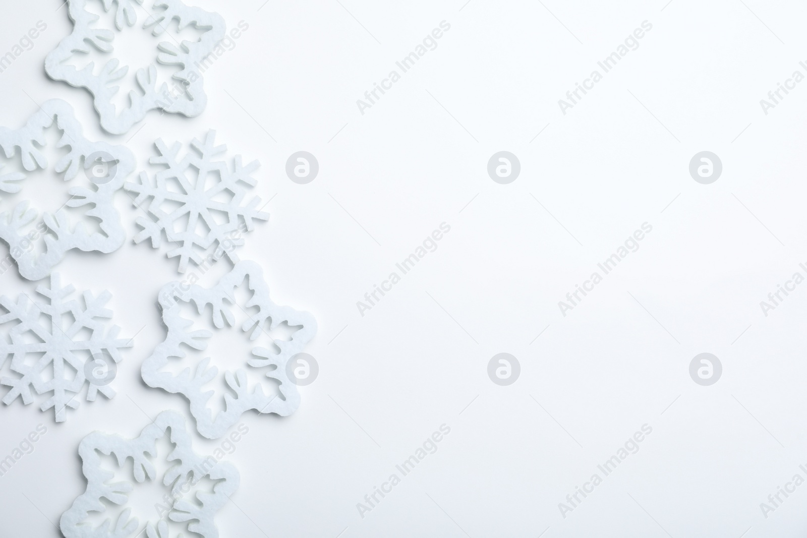 Photo of Beautiful decorative snowflakes on white background, flat lay. Space for text