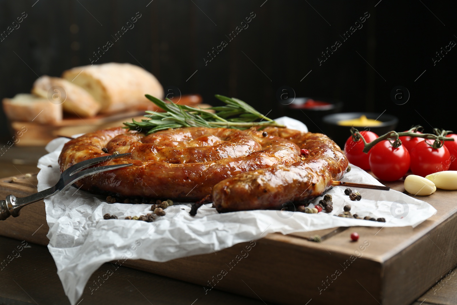 Photo of Delicious homemade sausage with spices and tomatoes served on table, closeup