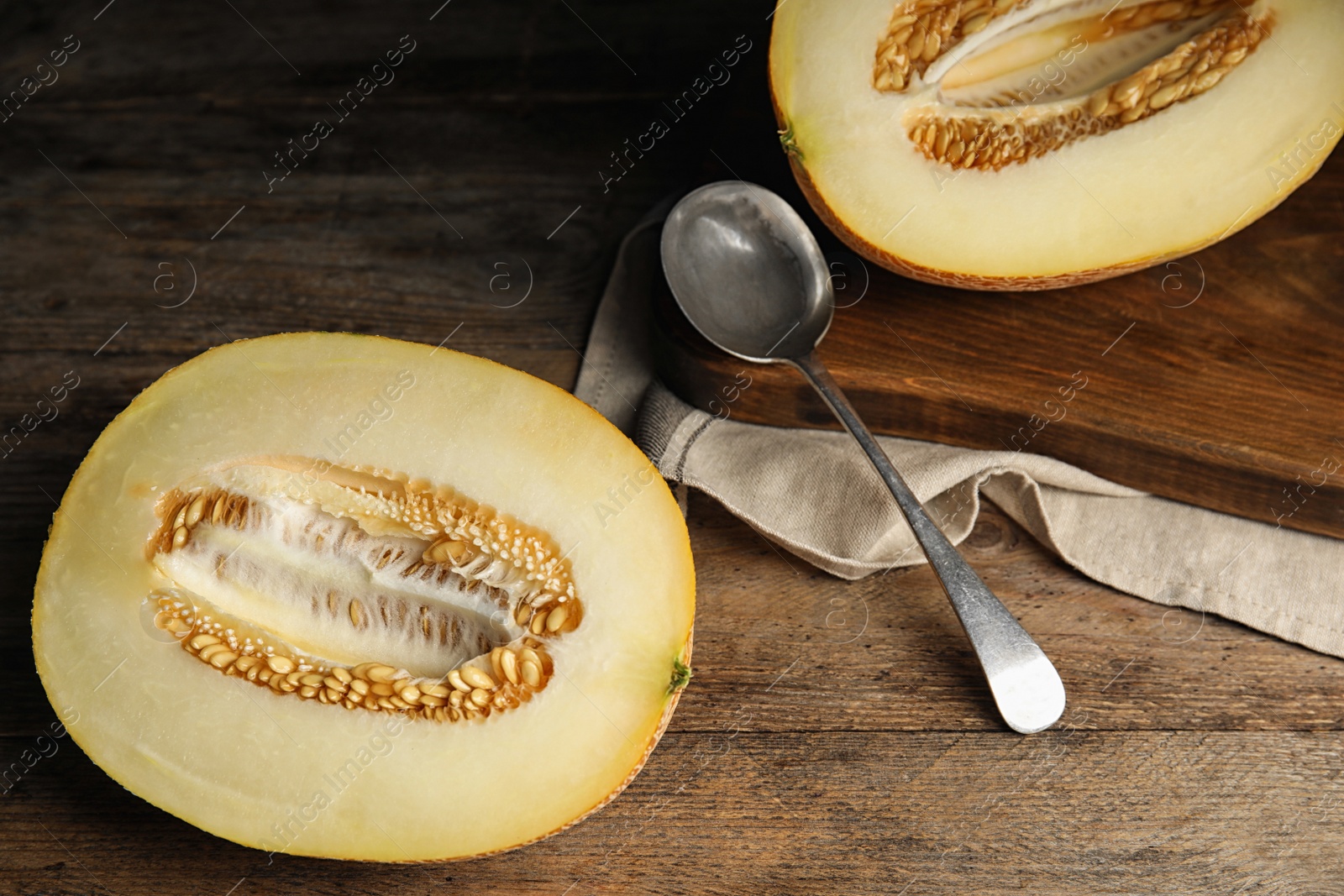 Photo of Halves of tasty ripe melon on wooden table