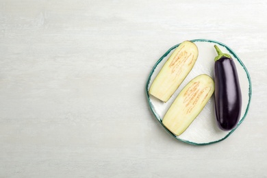 Photo of Plate with ripe eggplants on light background, top view