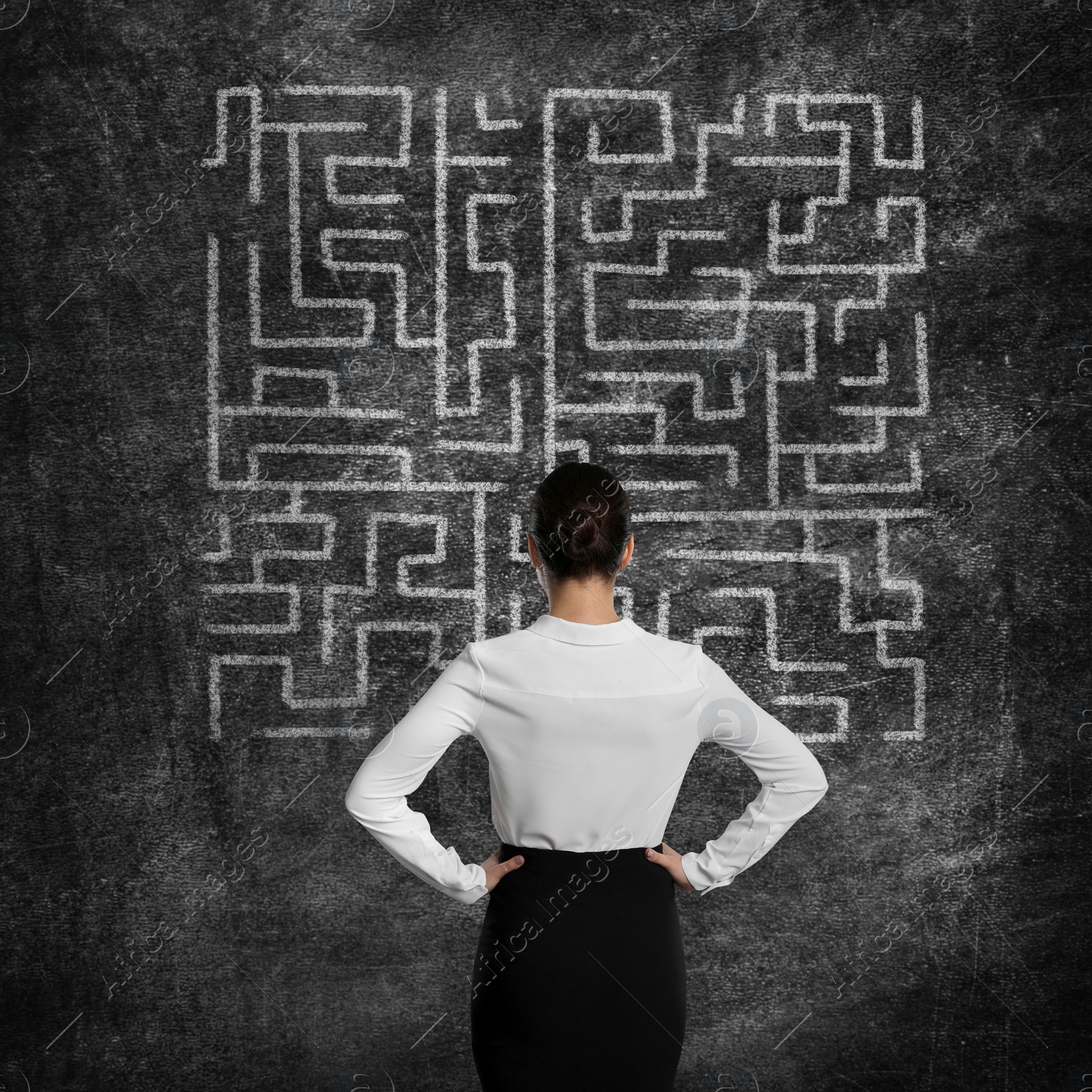 Image of Businesswoman looking at chalkboard with illustration of maze