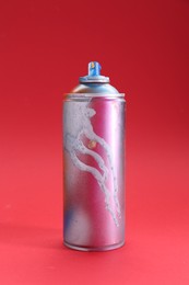 Photo of One can of bright spray paint on red background