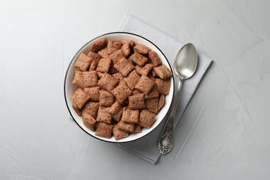 Photo of Sweet crispy corn pads in bowl and spoon on light table, flat lay