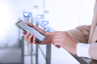 Young woman using modern smartphone indoors, closeup