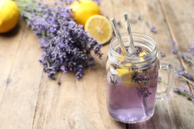 Photo of Fresh delicious lemonade with lavender in masson jar on wooden table. Space for text