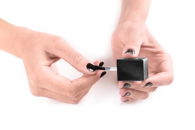 Woman applying nail polish on white background, closeup