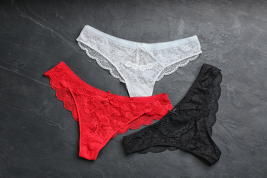 Photo of Sexy women's underwear on black stone background, flat lay