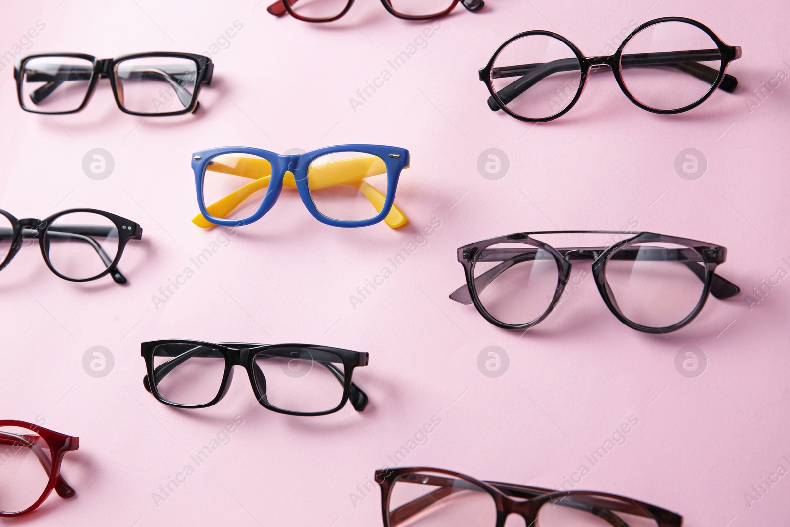 Photo of Colorful glasses among black ones on pink background. Diversity concept