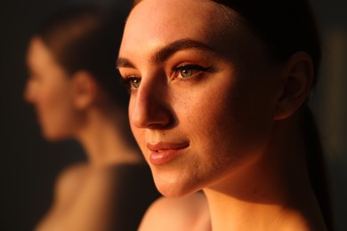 Photo of Fashionable portrait of beautiful woman with fake freckles on blurred background, closeup