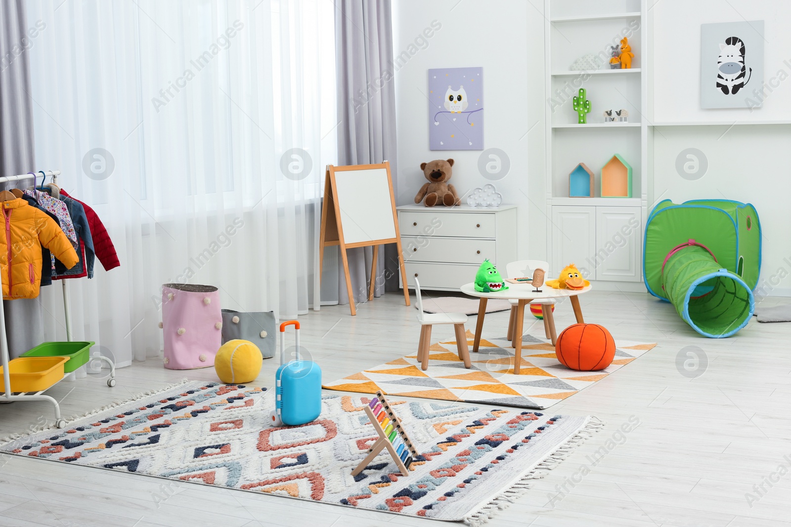 Photo of Child`s playroom with different toys and modern furniture. Stylish kindergarten interior