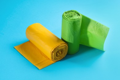 Photo of Rolls of garbage bags on light blue background
