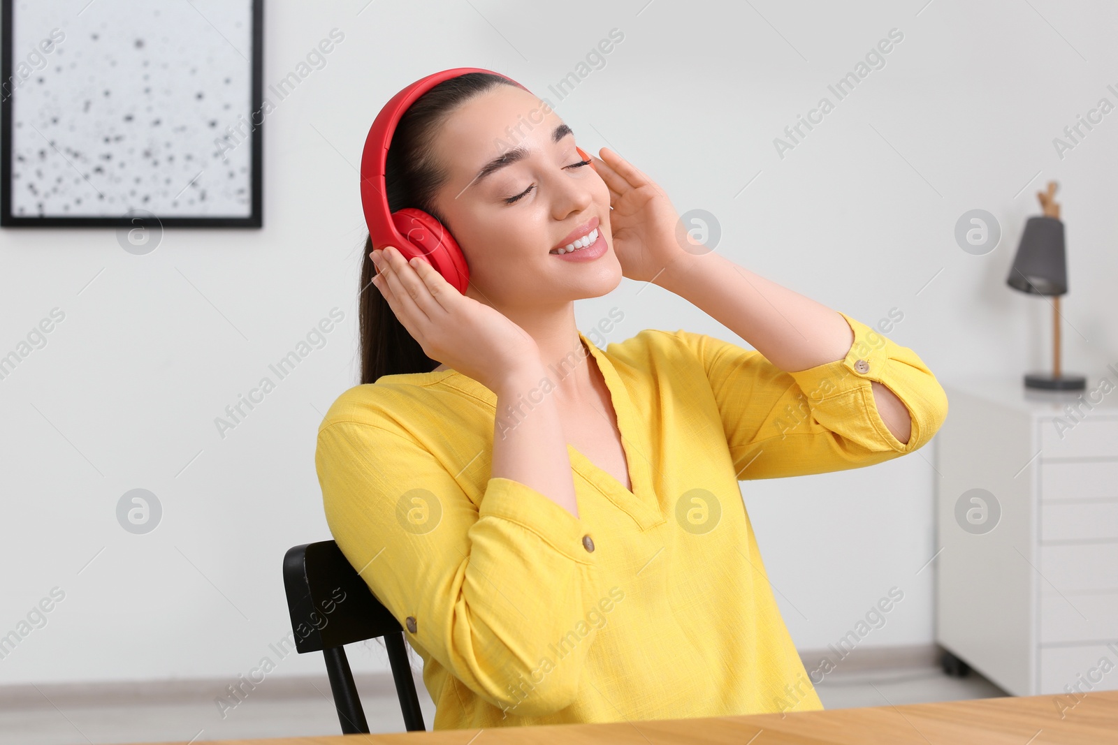 Photo of Happy woman in headphones enjoying music at home