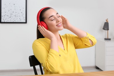Happy woman in headphones enjoying music at home