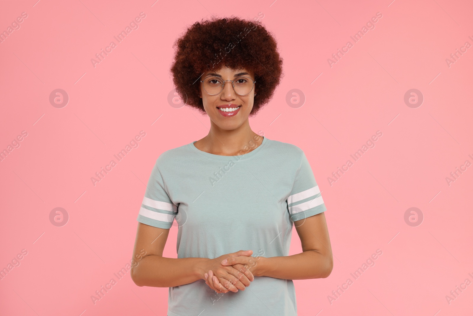 Photo of Portrait of happy young woman on pink background