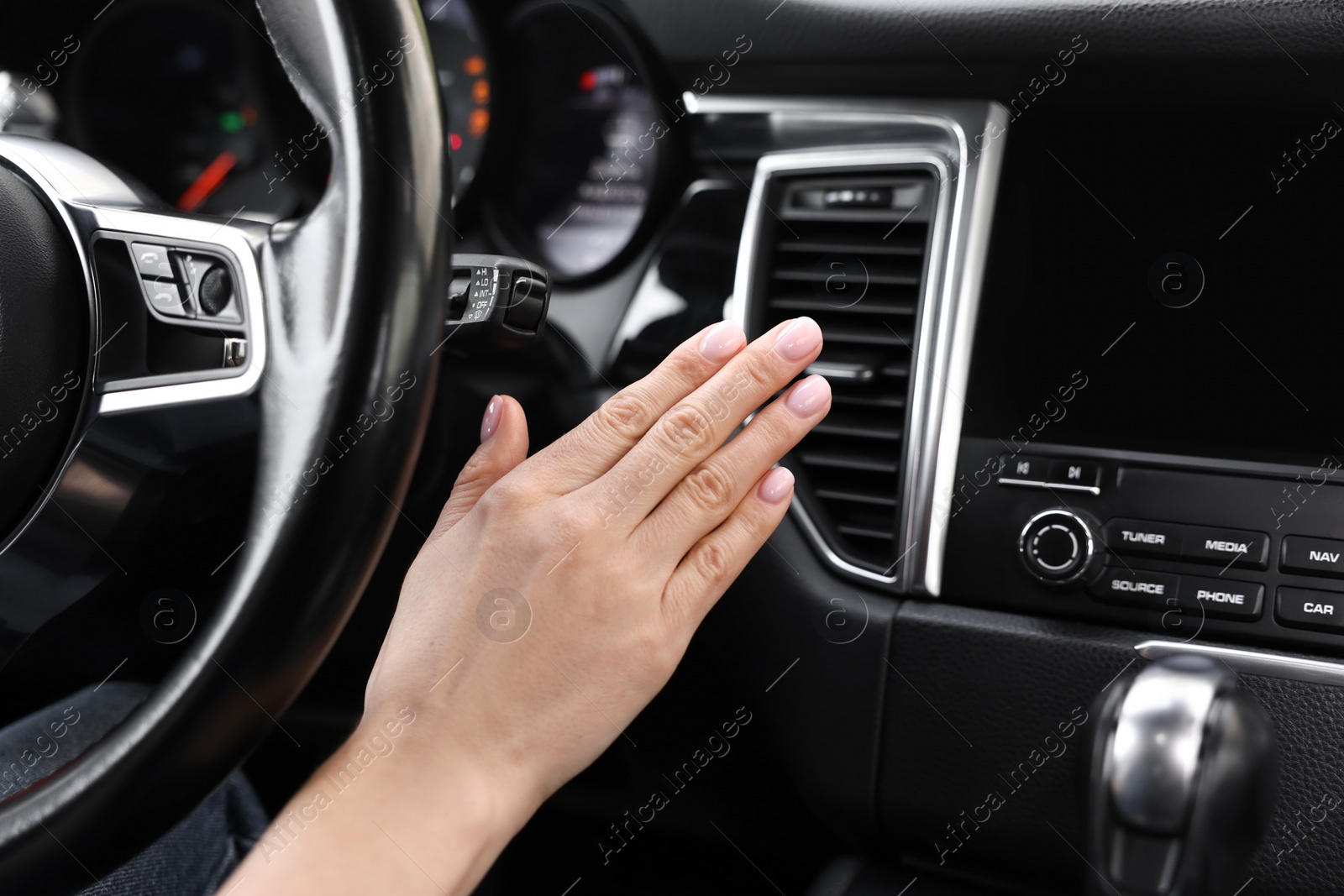 Photo of Woman checking air conditioner in her car, closeup