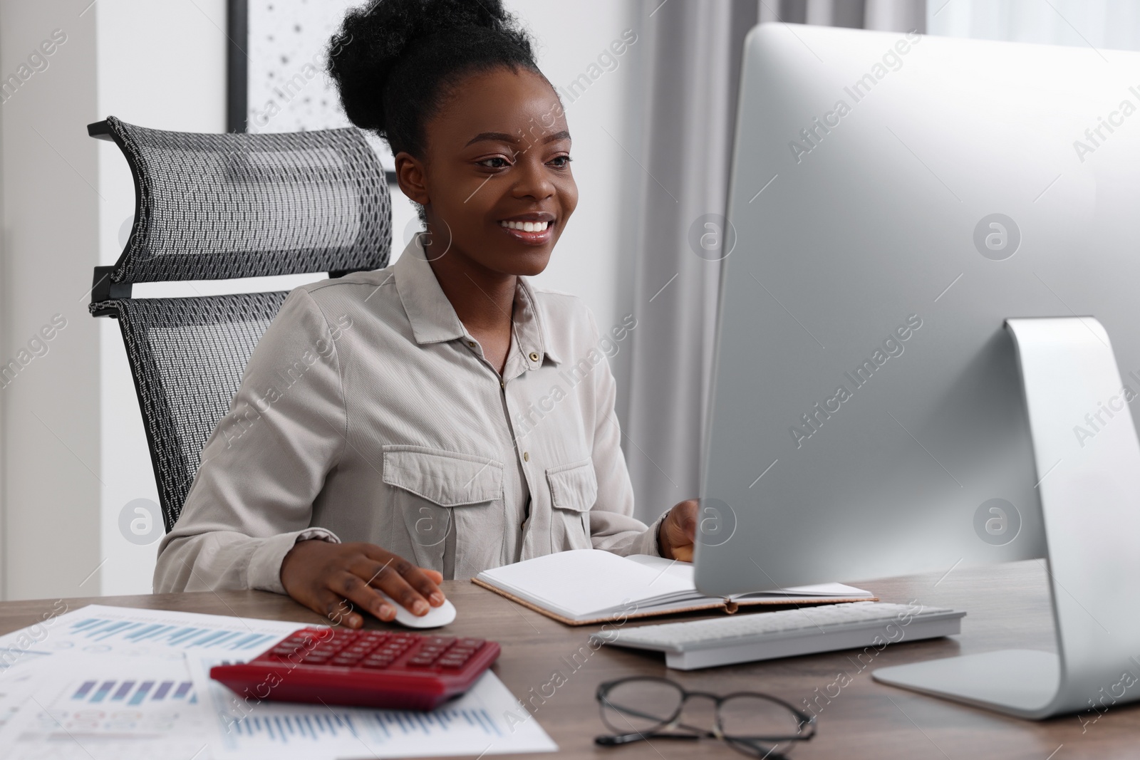 Photo of Professional accountant working on computer at wooden desk in office