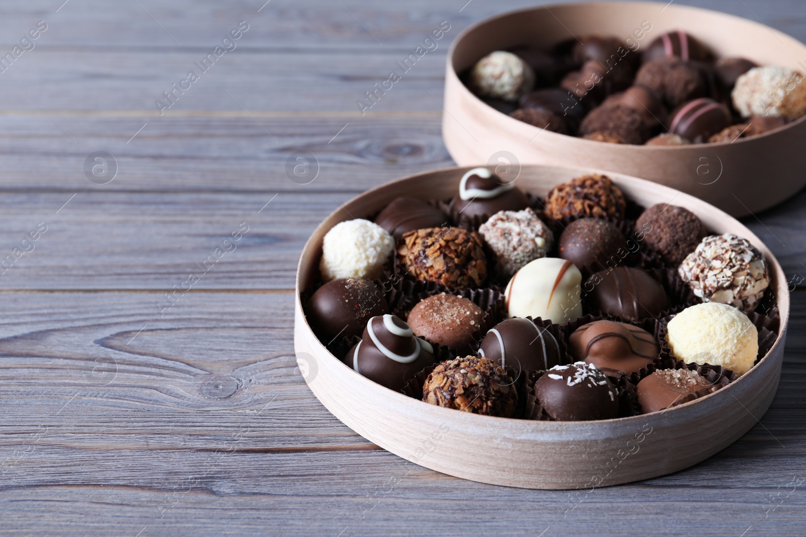 Photo of Boxes with tasty chocolate candies on wooden table