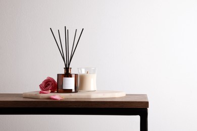 Photo of Composition with aromatic reed air freshener on wooden table, space for text