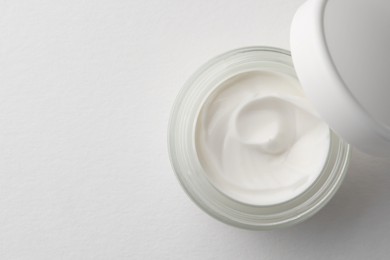 Photo of Jar of face cream on white background, top view. Space for text