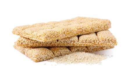 Photo of Delicious sweet kozinaki bars and sesame seeds on white background