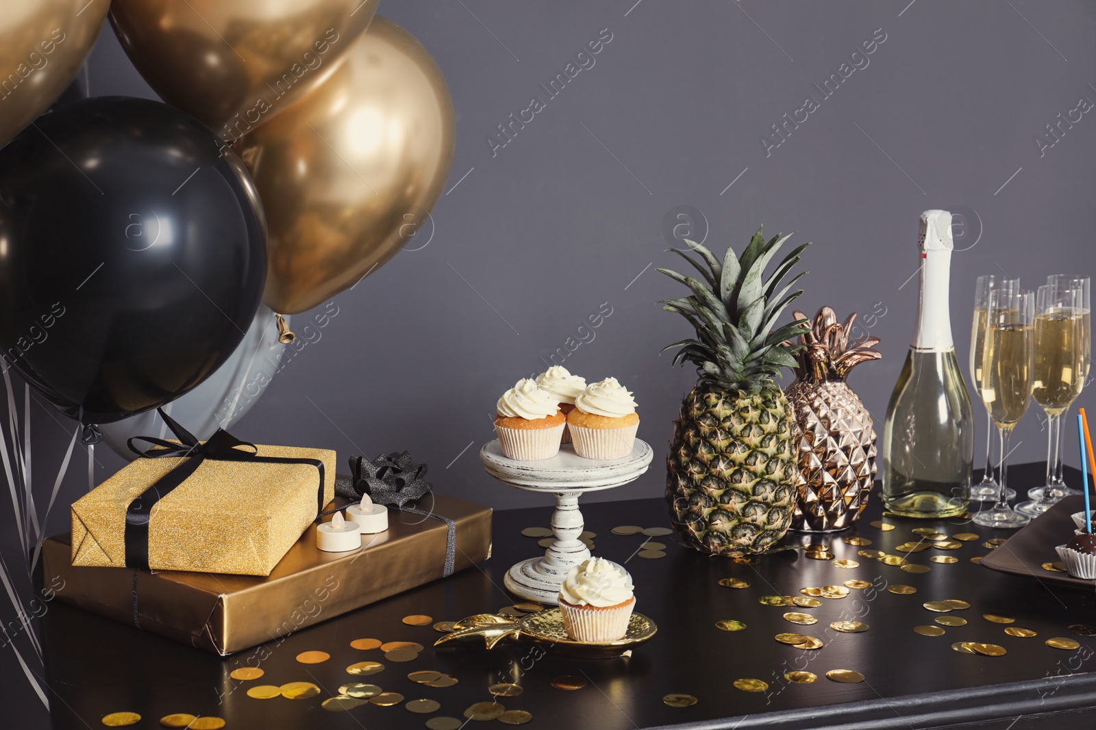 Photo of Party treats and items on table in room decorated with balloons