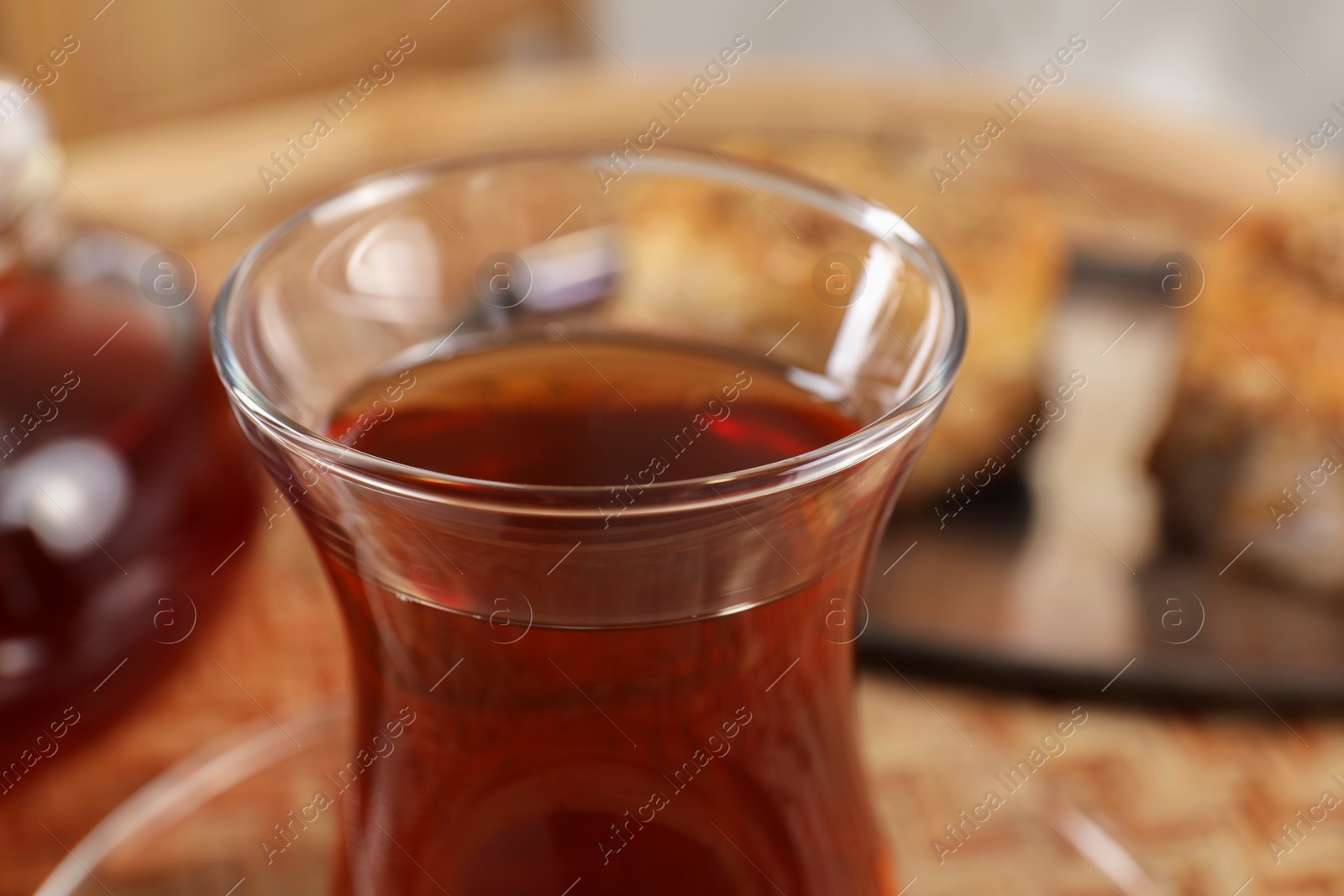 Photo of Traditional Turkish tea in glass on table, closeup