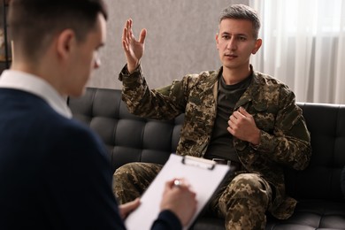 Professional psychotherapist working with military man in office