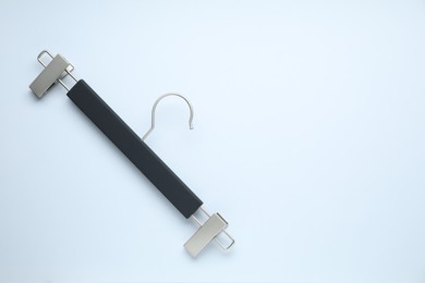 Photo of Empty hanger with clips on light background, top view. Space for text