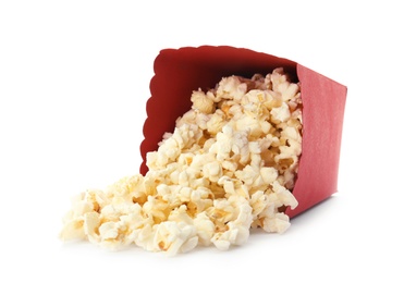 Overturned red bucket with delicious popcorn on white background